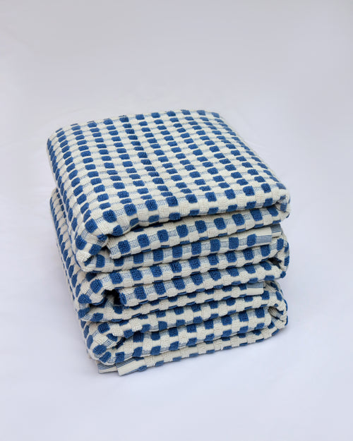 Stack of blue and white checkered towels on a white background