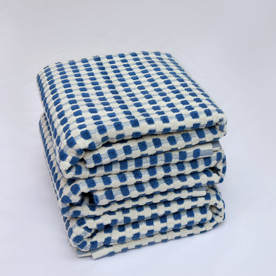Stack of blue and white checkered towels on a white background