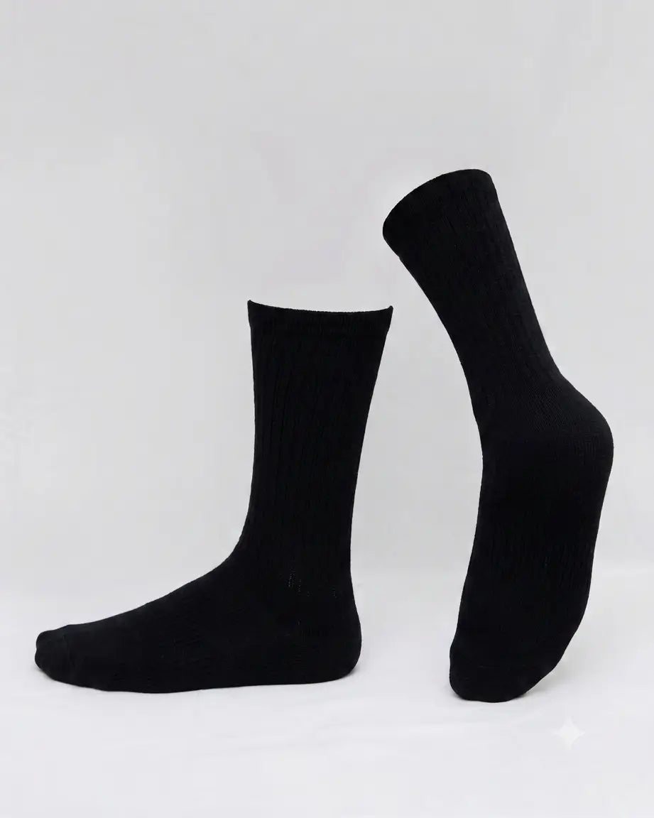 A pair of black ribbed crew socks displayed on invisible forms against a clean white studio background.
