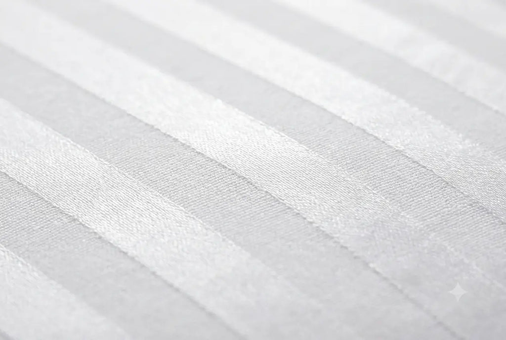 A close-up of a white or light gray striped fabric with a subtle woven texture and soft diagonal bands.