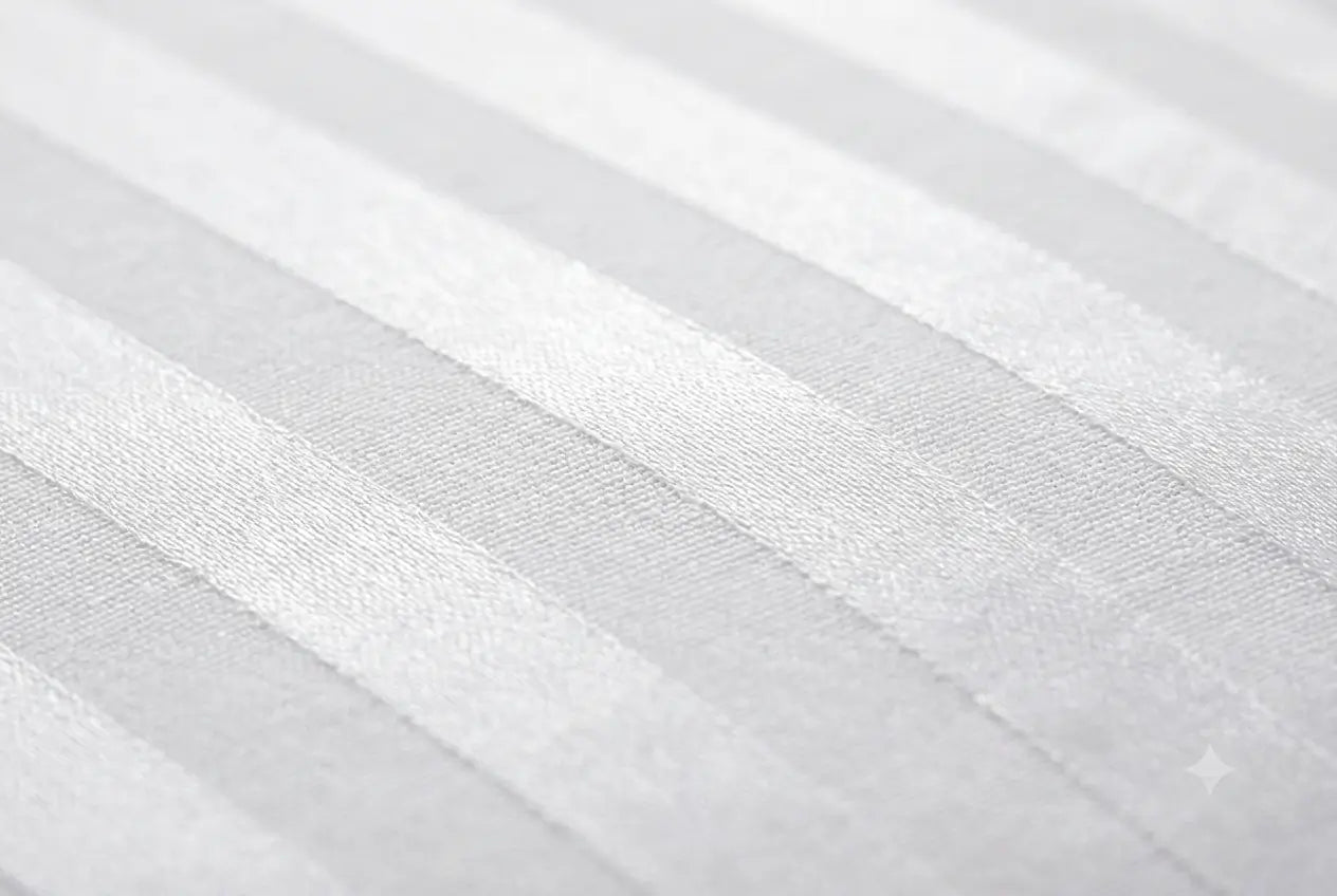A close-up of a white or light gray striped fabric with a subtle woven texture and soft diagonal bands.